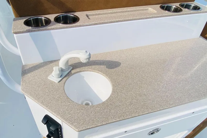 Slide: The Image of 2021 Sea Hunt Ultra 265 SE boat sink and countertop with cup holders. - 8