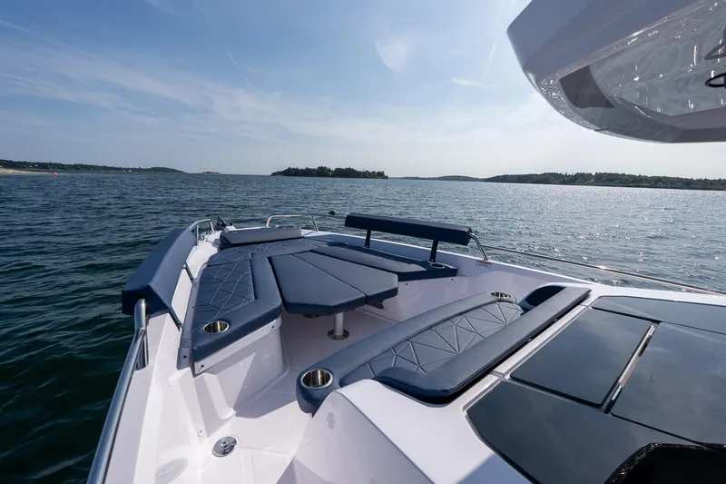Slide: The Image of 2026 Axopar 29 XC Cross Cabin boat on serene water, featuring sleek seating and modern design. - 19