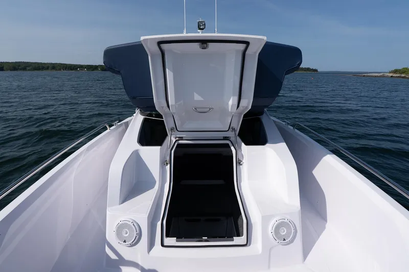 Slide: The Image of 2026 Axopar 29 XC Cross Cabin boat with open hatch on calm water. - 21
