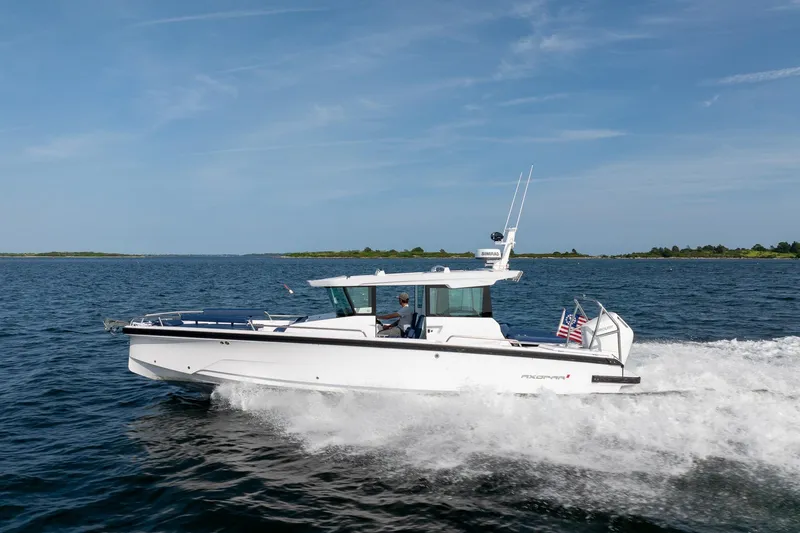 Slide: The Image of 2026 Axopar 29 XC Cross Cabin boat cruising on open water. - 3