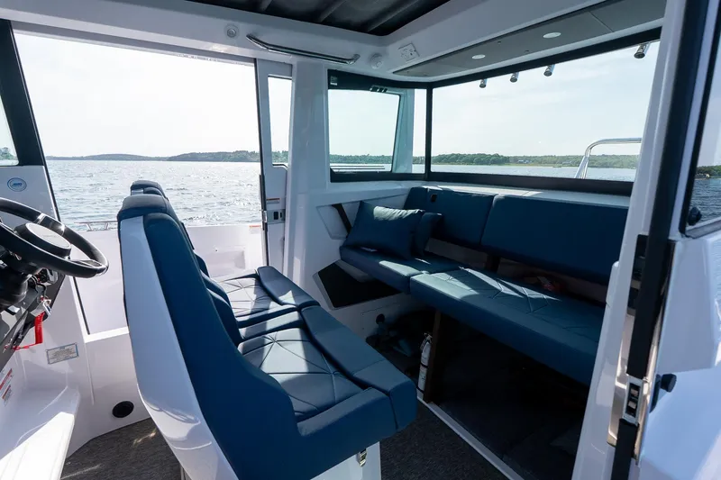 Slide: The Image of Interior of 2026 Axopar 29 XC Cross Cabin with blue seating and ocean view. - 34