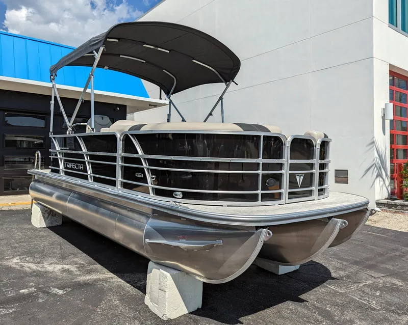 Slide: The Image of 2022 Trifecta 20C LE pontoon boat with Yamaha outboard motor, docked under sunny skies. - 3