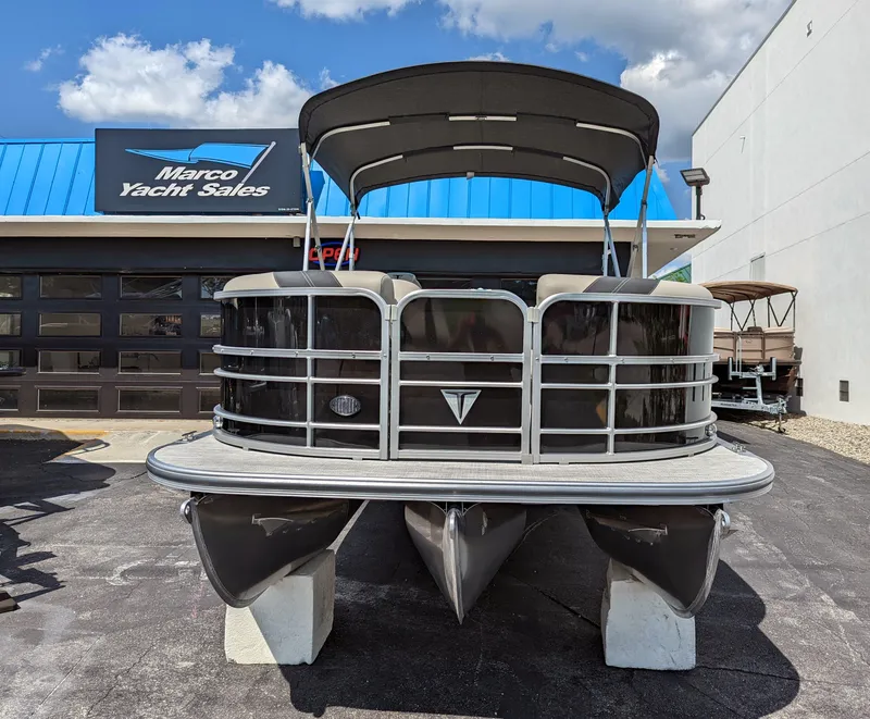 Slide: The Image of 2022 Trifecta 20C LE pontoon boat docked with canopy, surrounded by tropical scenery. - 4