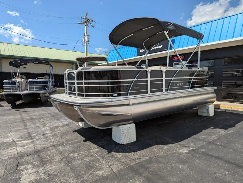 Slide: The Image of 2022 Trifecta 20C LE pontoon boat on trailer, surrounded by other boats. - 5