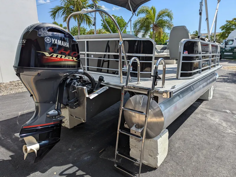 Slide: The Image of 2022 Trifecta 20C LE pontoon boat docked with Yamaha outboard motor. - 6