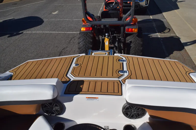 Slide: The Image of 2023 Starcraft SVX 210 IO boat with teak deck, parked behind a tractor. - 11
