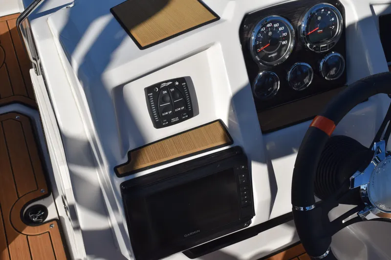 Slide: The Image of 2023 Starcraft SVX 210 IO dashboard with gauges and controls, featuring a Garmin display. - 15