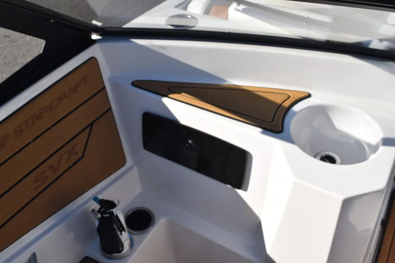 Slide: The Image of 2023 Starcraft SVX 210 IO boat interior with wood accents and cup holder. - 20