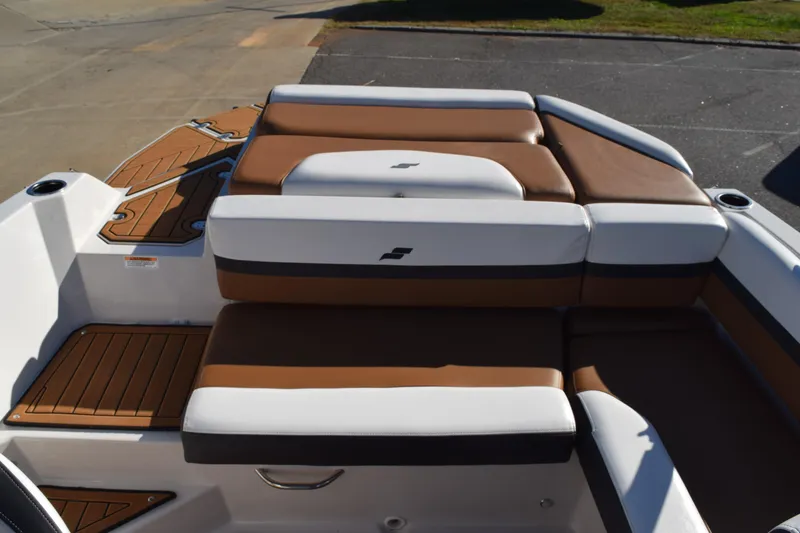 Slide: The Image of 2023 Starcraft SVX 210 IO boat interior with brown and white cushioned seating. - 23