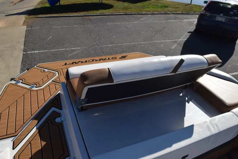 Slide: The Image of 2023 Starcraft SVX 210 IO boat with brown and white seating, docked in a parking area. - 24