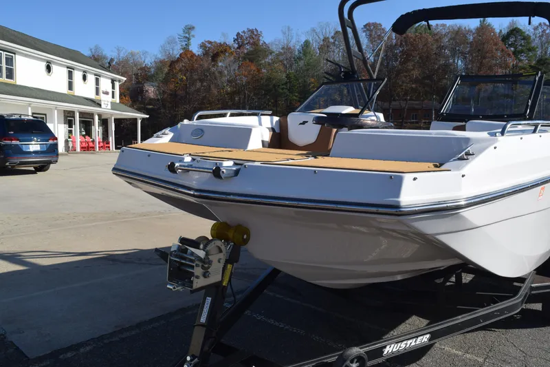 Slide: The Image of 2023 Starcraft SVX 210 IO boat on trailer, parked outside a building. - 3