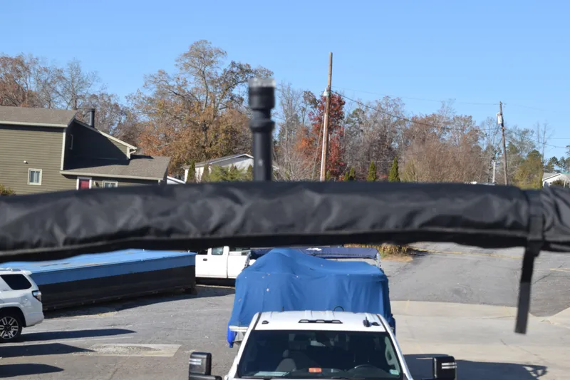 Slide: The Image of 2023 Starcraft SVX 210 IO boat covered, parked near vehicles and houses. - 37