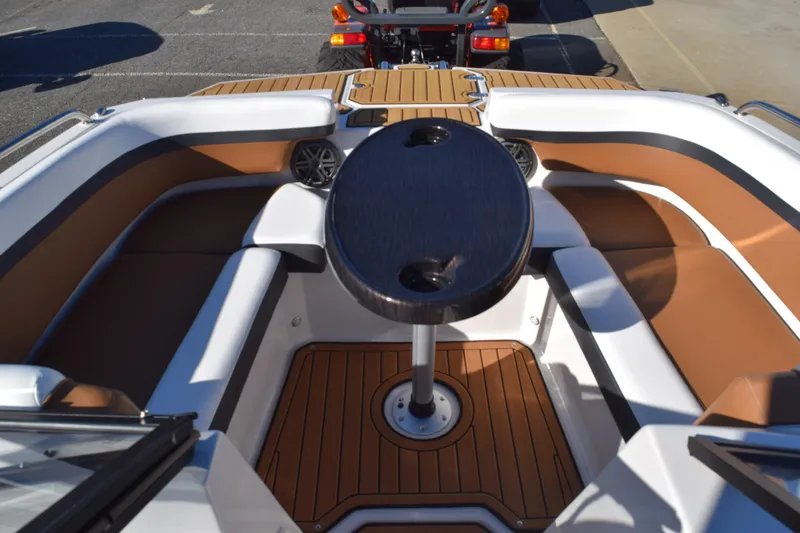Slide: The Image of 2023 Starcraft SVX 210 IO boat interior with brown seating and central table. - 9