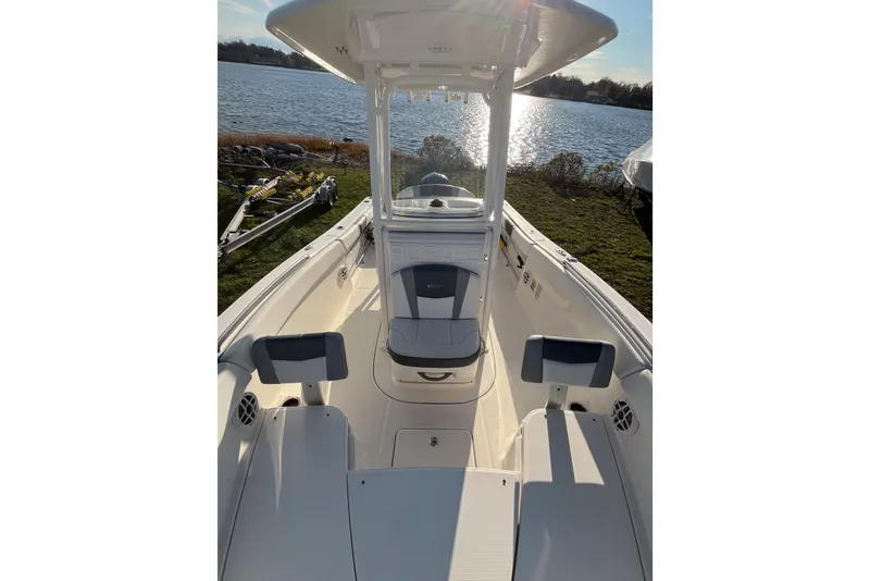 Slide: The Image of 2021 Robalo R230 Center Console boat interior with seating, near a scenic lake. - 14