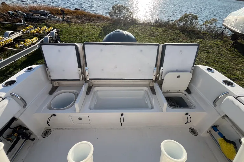 Slide: The Image of 2021 Robalo R230 Center Console boat interior with open storage compartments by the water. - 4