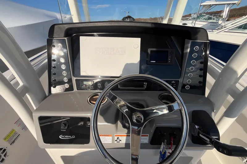 Slide: The Image of 2021 Robalo R230 Center Console boat dashboard with steering wheel and control panel. - 8