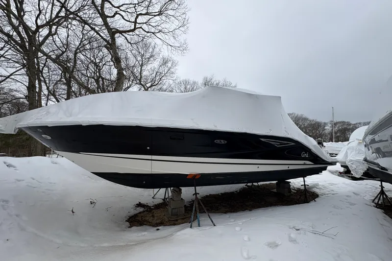 Slide: The Image of 2018 Sea Ray SLX 310 boat covered in snow, stored outdoors. - 2