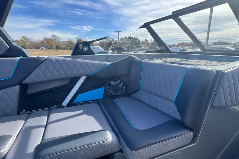 Slide: The Image of 2026 Tigé Z3 boat interior with modern seating and blue accents under a clear sky. - 13