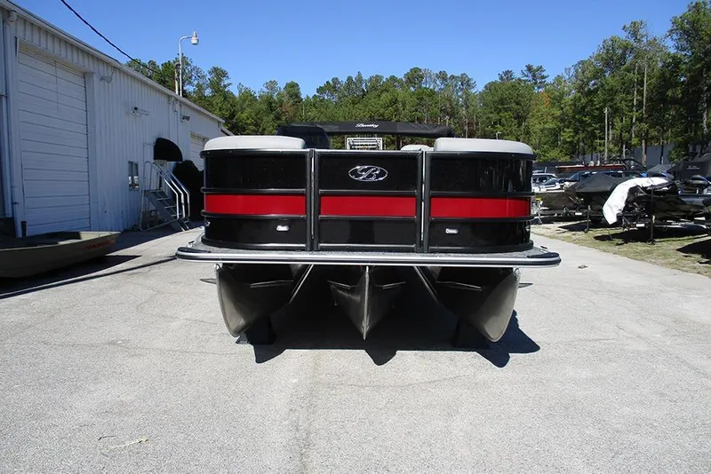 Slide: The Image of 2026 Bentley Pontoons Legacy 223 Swingback, black and red, parked outdoors near a warehouse. - 4