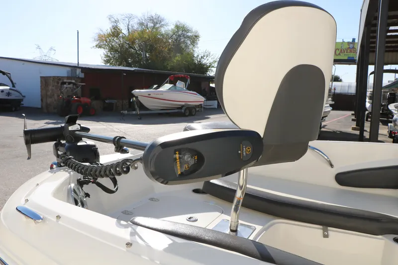 Slide: The Image of 2018 Stingray 182 SC boat with motor and seating, parked outdoors. - 13