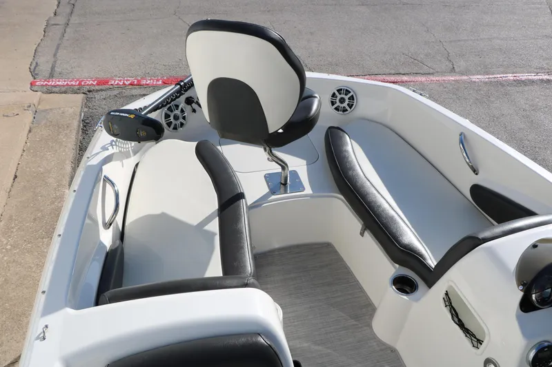 Slide: The Image of 2018 Stingray 182 SC boat interior with black and white seating and steering console. - 20