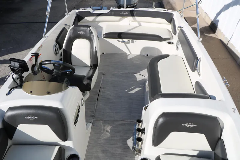 Slide: The Image of 2018 Stingray 182 SC boat interior with seating and steering console. - 22