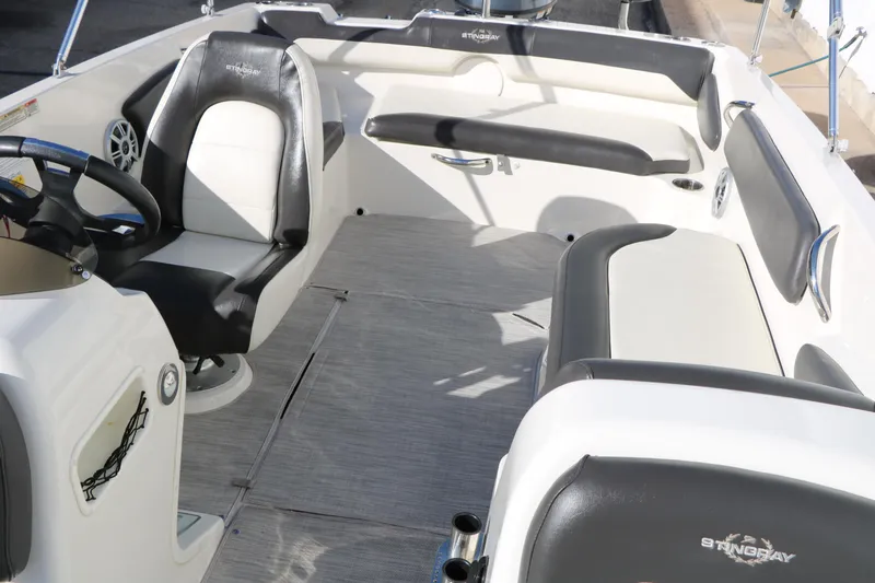 Slide: The Image of 2018 Stingray 182 SC boat interior with black and white seating and steering wheel. - 24