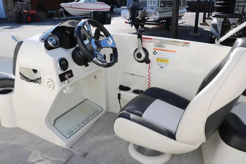 Slide: The Image of 2018 Stingray 182 SC boat cockpit with steering wheel and captain's chair. - 28