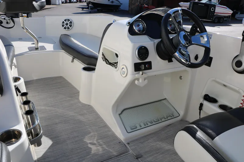 Slide: The Image of 2018 Stingray 182 SC boat interior with steering wheel and seating area. - 29