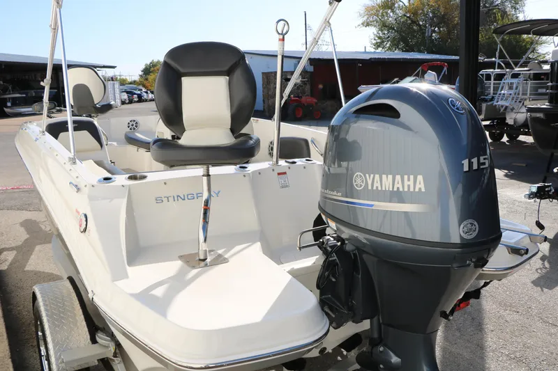 Slide: The Image of 2018 Stingray 182 SC boat with Yamaha 115 outboard motor, parked on a trailer. - 5