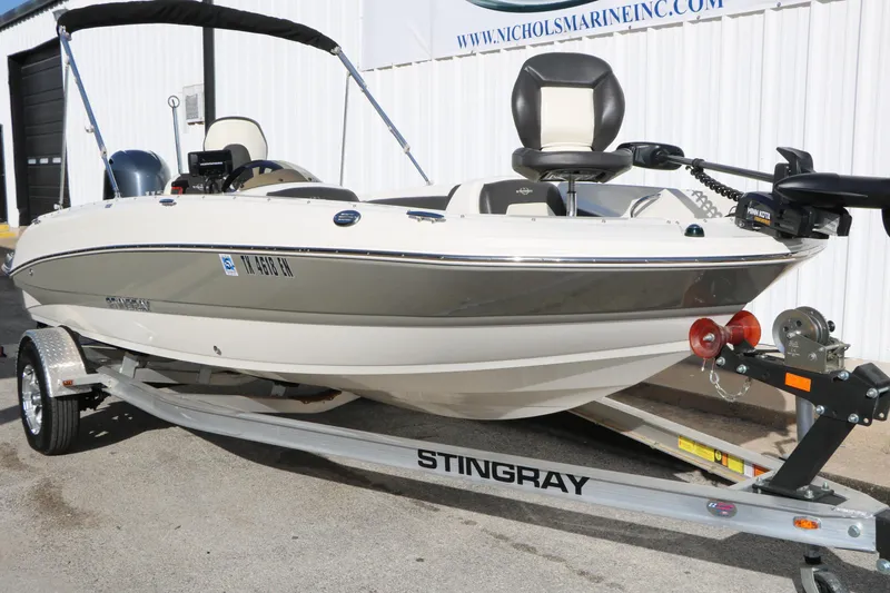 Slide: The Image of 2018 Stingray 182 SC boat on trailer, displayed outdoors at Nichols Marine. - 9