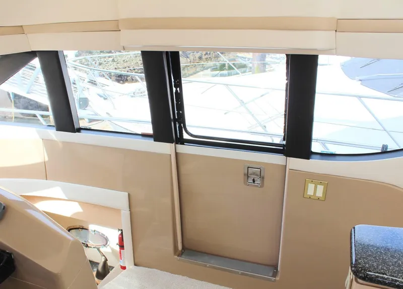 Slide: The Image of Interior view of 2000 Carver 530 Voyager Pilothouse with large windows and beige accents. - 11