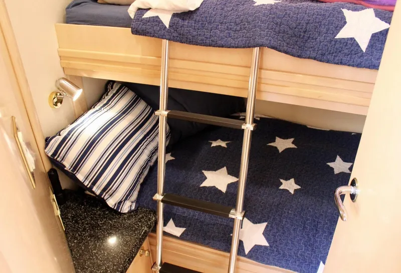 Slide: The Image of Bunk beds with star-patterned bedding in a 2000 Carver 530 Voyager Pilothouse cabin. - 12