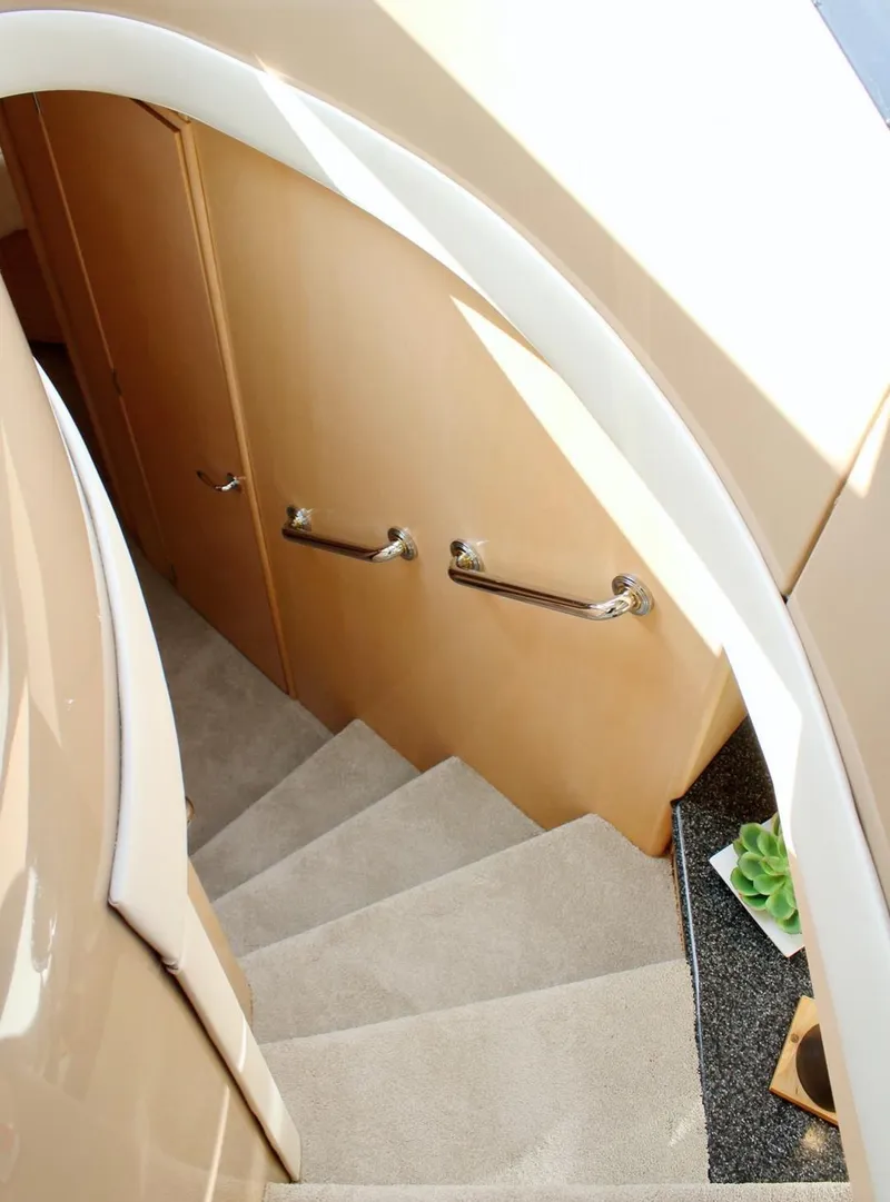 Slide: The Image of Staircase inside 2000 Carver 530 Voyager Pilothouse yacht with beige carpet and wooden handrails. - 14