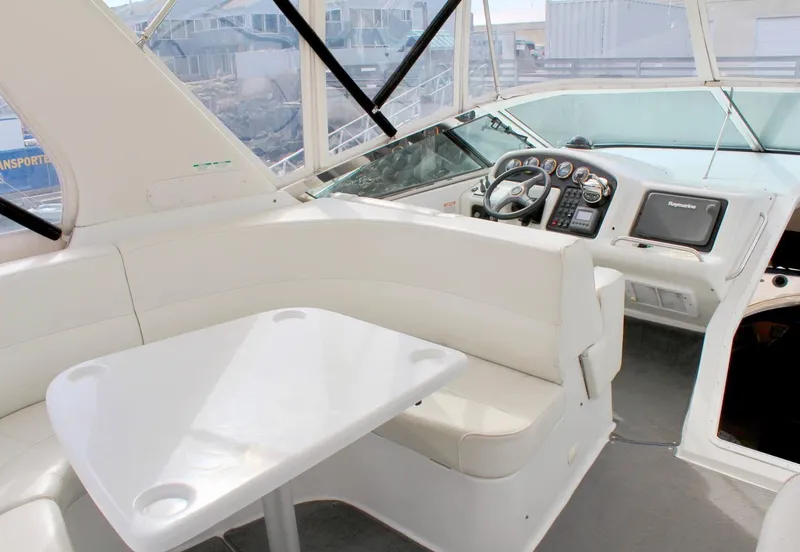 Slide: The Image of Interior of 2000 Carver 530 Voyager Pilothouse with white seating and navigation controls. - 19