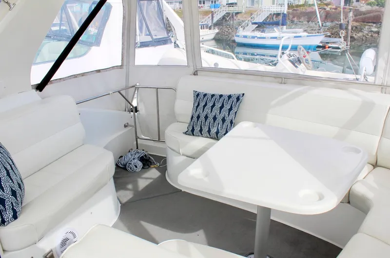 Slide: The Image of Interior of 2000 Carver 530 Voyager Pilothouse with white seating and table. - 20