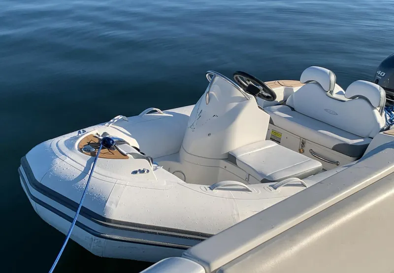 Slide: The Image of Inflatable boat docked beside Carver 530 Voyager Pilothouse, 2000 model, on calm water. - 24