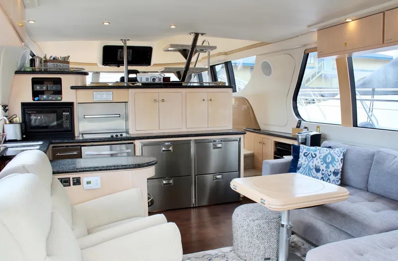 Slide: The Image of Luxurious interior of 2000 Carver 530 Voyager Pilothouse yacht with modern kitchen and seating area. - 3