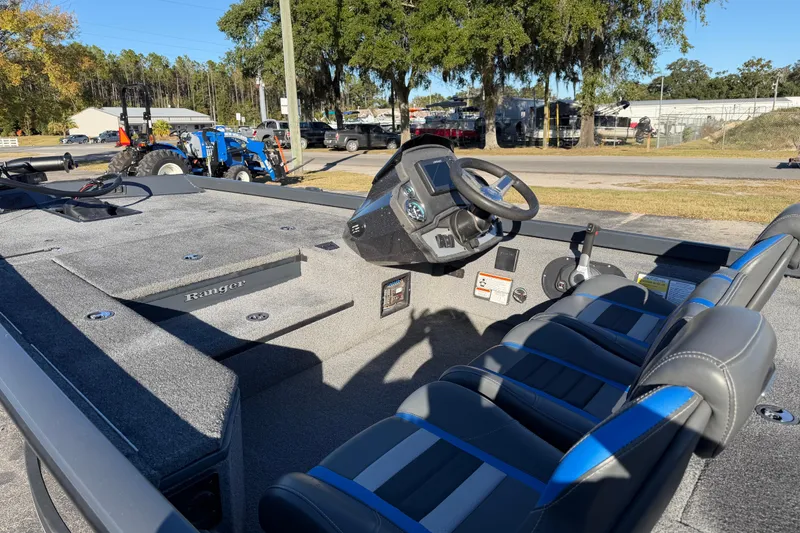 Slide: The Image of 2022 Ranger RT178 boat interior with steering wheel and seating, parked outdoors. - 15