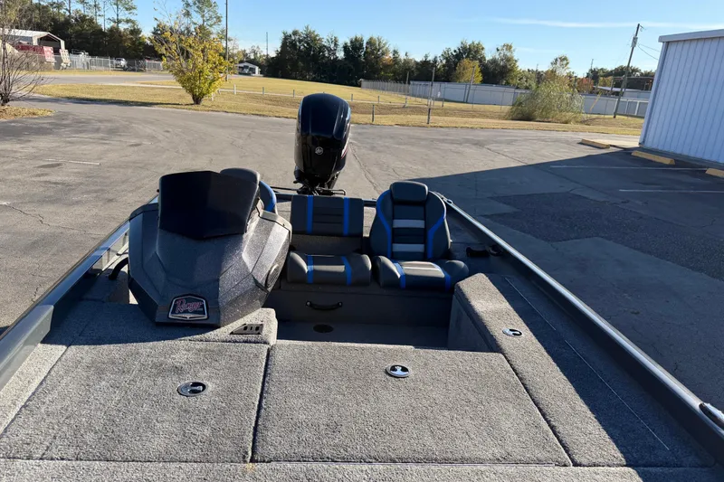 Slide: The Image of 2022 Ranger RT178 boat interior with seats and motor in a parking lot. - 9