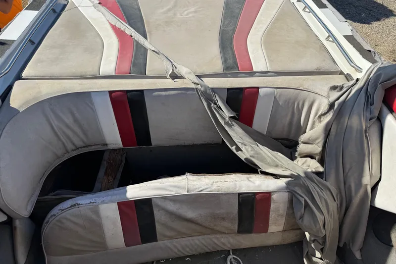 Slide: The Image of 1987 Chaparral Villain IV boat interior with worn upholstery and torn fabric. - 11