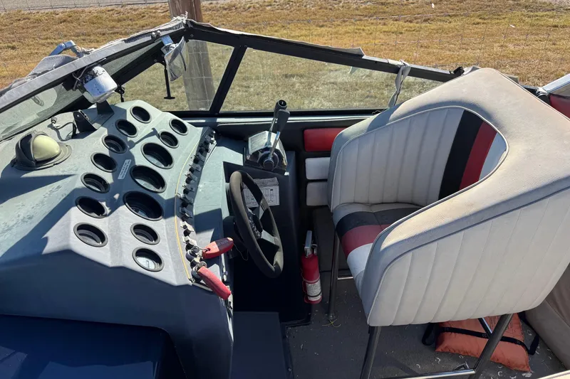 Slide: The Image of 1987 Chaparral Villain IV boat cockpit with steering wheel, gauges, and upholstered seat. - 12