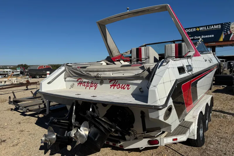 Slide: The Image of 1987 Chaparral Villain IV boat with "Happy Hour" text, parked on a trailer. - 4