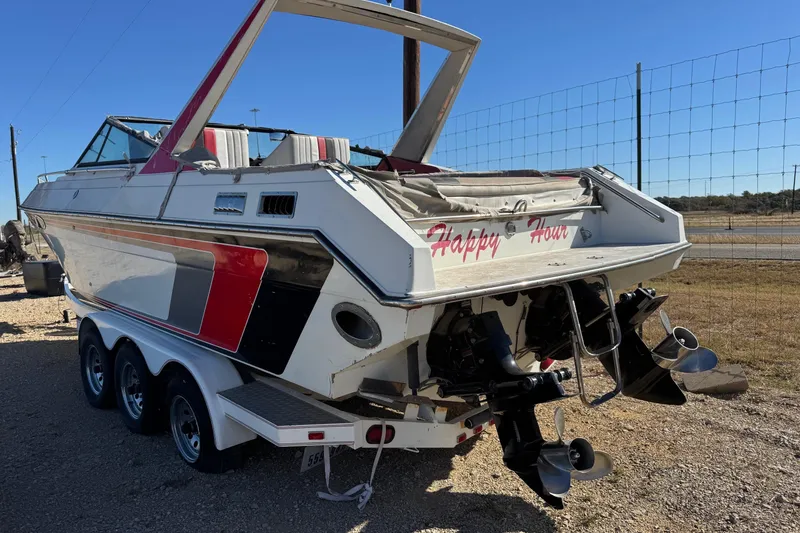 Slide: The Image of 1987 Chaparral Villain IV boat with dual propellers, named "Happy Hour," on a trailer. - 8