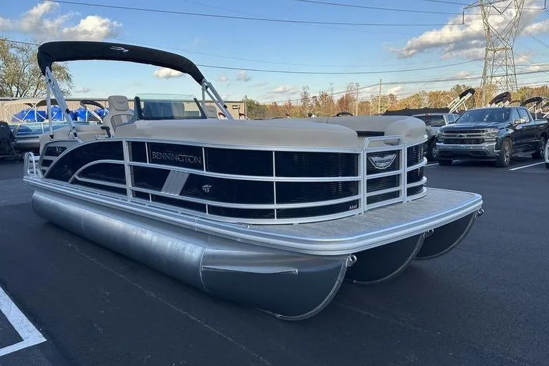 Slide: The Image of 2026 Bennington M Quad Bench 22 MFB pontoon boat parked outdoors. - 5