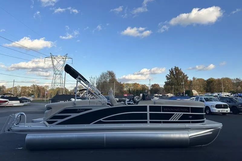 Slide: The Image of 2026 Bennington M Quad Bench 22 MFB pontoon boat under a clear blue sky. - 9
