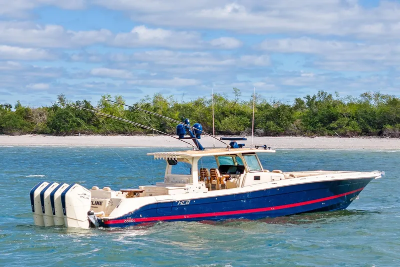 The Image of 2023 HCB 53 Suenos RXV boat cruising on blue water near a sandy shoreline. - 0