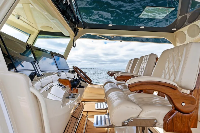 Slide: The Image of 2023 HCB 53 Suenos RXV luxury boat interior with plush seating and advanced controls. - 11
