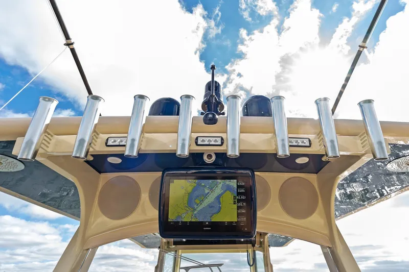 Slide: The Image of 2023 HCB 53 Suenos RXV boat dashboard with navigation display and rod holders. - 25