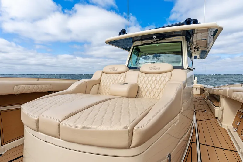 Slide: The Image of 2023 HCB 53 Suenos RXV luxury boat with beige seating and ocean backdrop. - 19